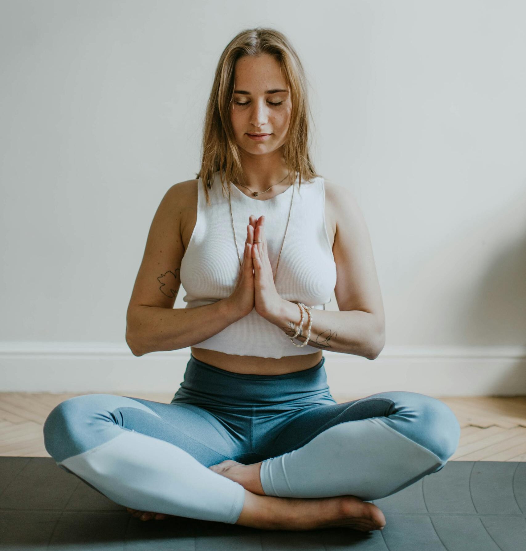 A serene image of a woman practicing meditation indoors, promoting mindfulness and wellbeing.